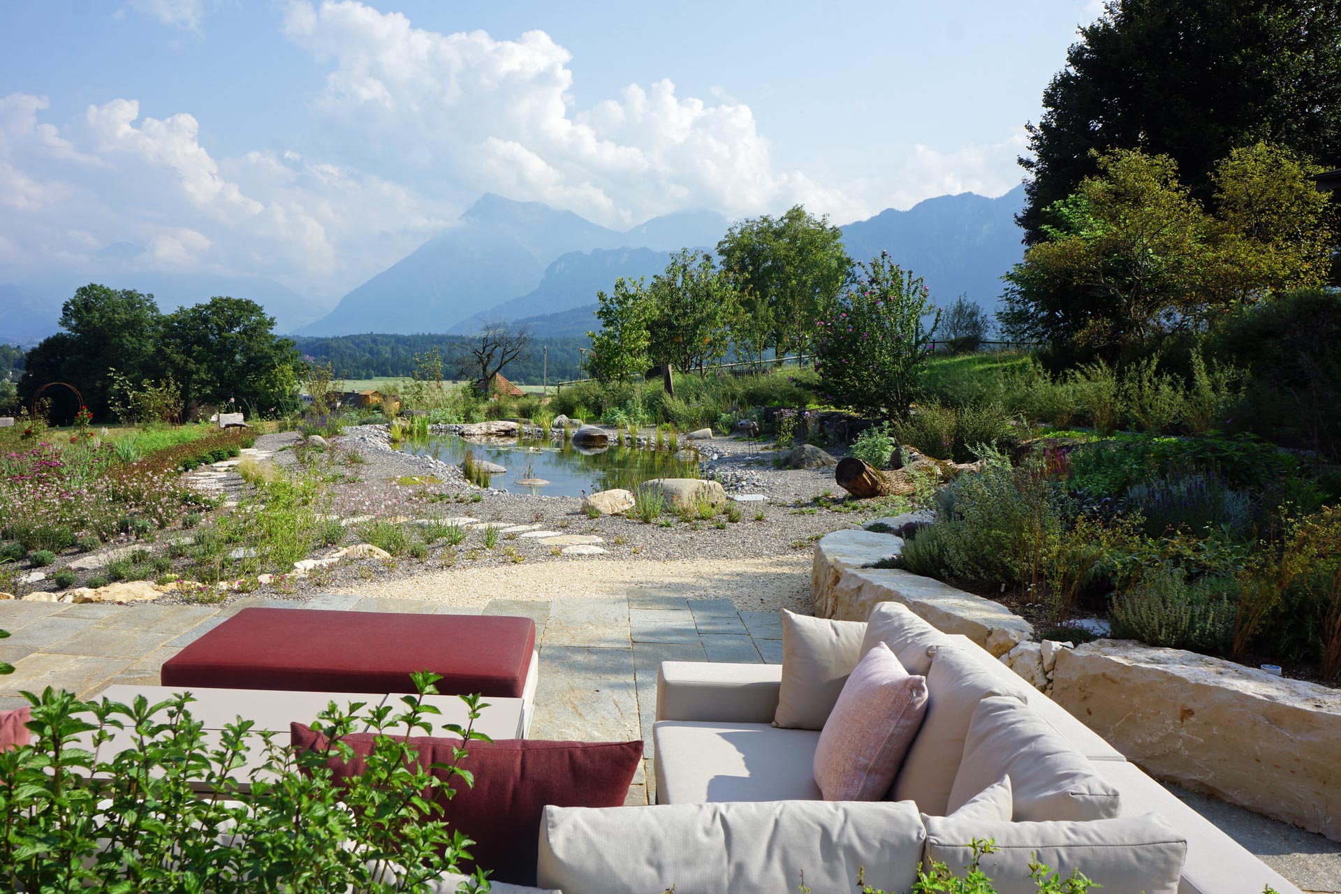 Gartengestaltung: Ein harmonisch angelegter Garten mit verschiedenen Pflanzen, Wegen und Sitzbereichen in ländlicher Umgebung